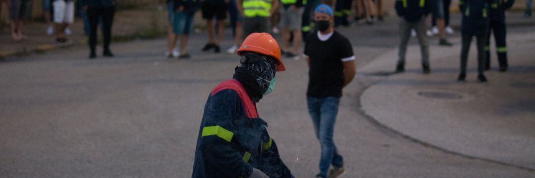 Un manifestante tira un petardo durante una concentración nocturna convocada por el comité de Alcoa San Cibrao