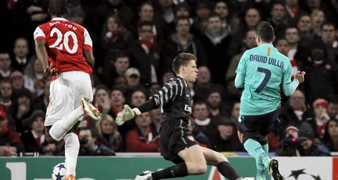 El delantero del FC Barcelona David Villa bate al portero del Arsenal, Wojciech Szczesny, para inaugurar el marcador durante su partido de ida de los octavos de final de la Liga de Campeones de fútbol que se juega en el estadio Emirates de Londres