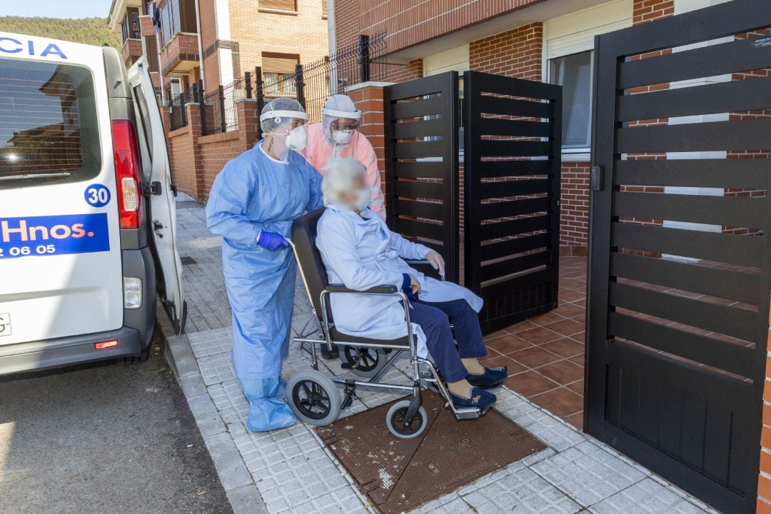 Una persona mayor es desplazada en silla de ruedas por personal sanitaria, en una imagen de archivo