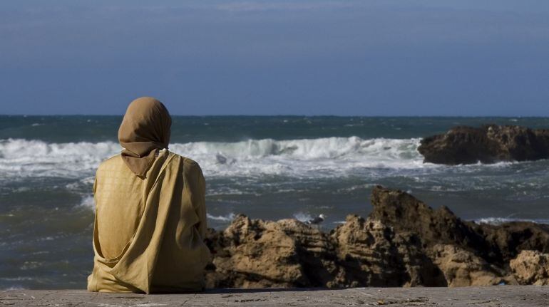 Mujer musulmana mirando al mar