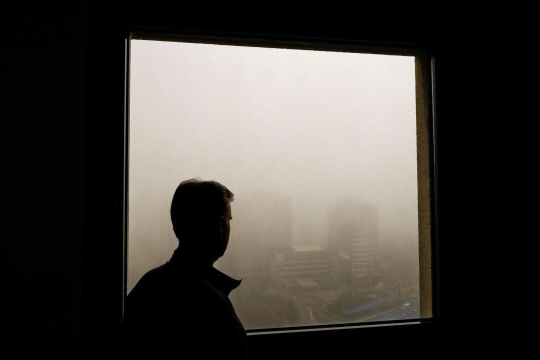 Un hombre mira la niebla en Madrid