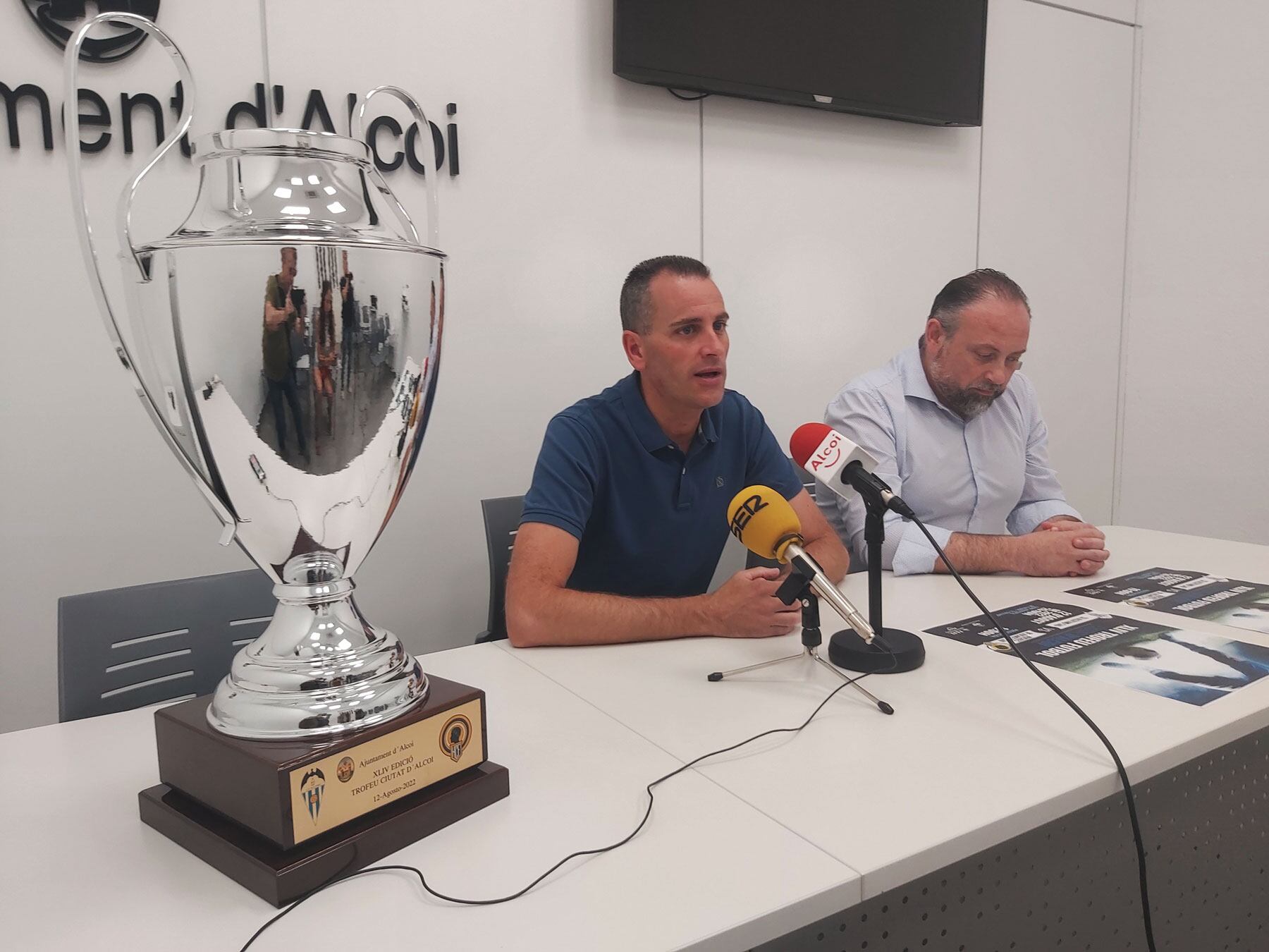 El trofeo en primer plano y el concejal de Deportes, Alberto Belda, y el presidente del Alcoyano, Toni Justicia, durante la presentación del partido