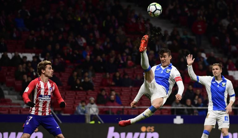 Martín Mantovani (c) realiza un acrobático despeje en el partido contra el C. Atlético de Madrid en el Estadio Wanda Metropolitano.