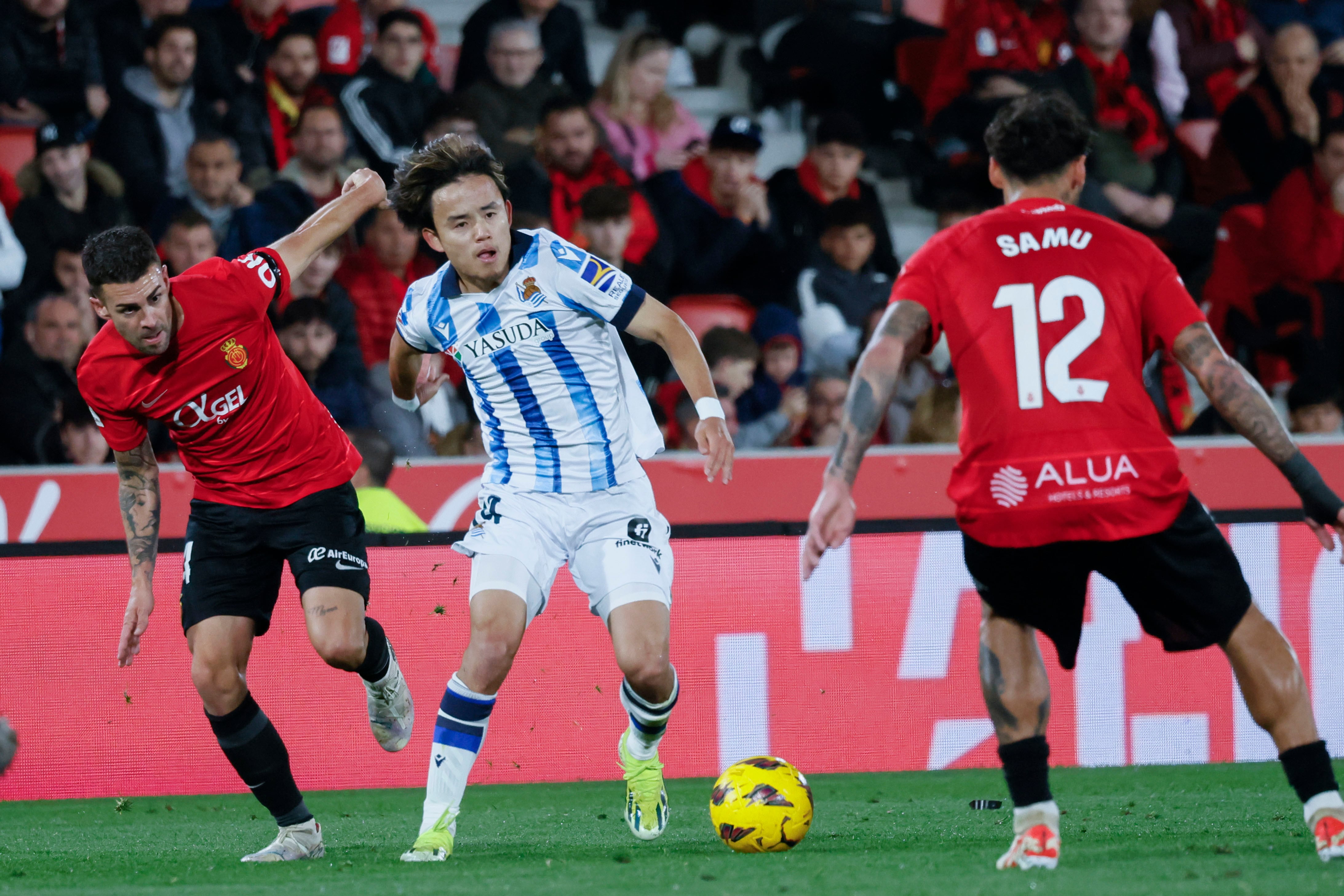 El centrocampista japonés de la Real Sociedad Take Kubo ante la marca de los jugadores del Mallorca. EFE/ Cati Cladera