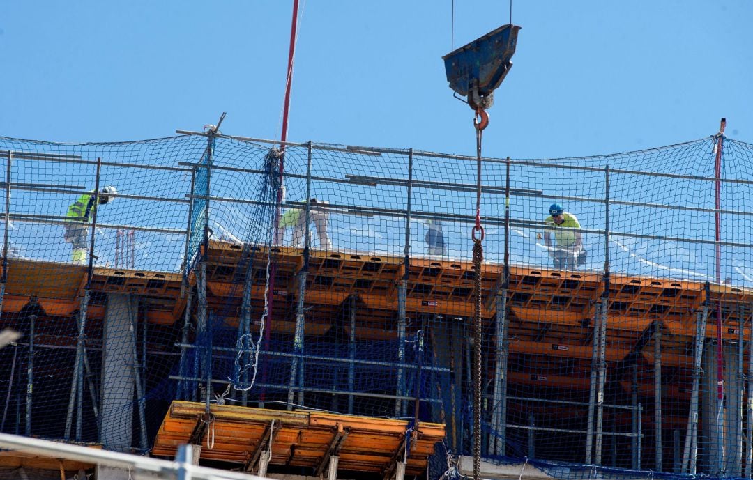 Unos obreros trabajan en un edificio, este martes, vigésimo primer día de confinamiento, en que las empresas consideradas no esenciales vuelven a la actividad