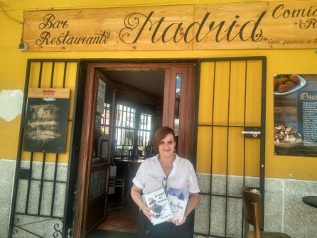 Andrea Pérez, cocinera del bar Madrid, con dos libros de la ruta literaria