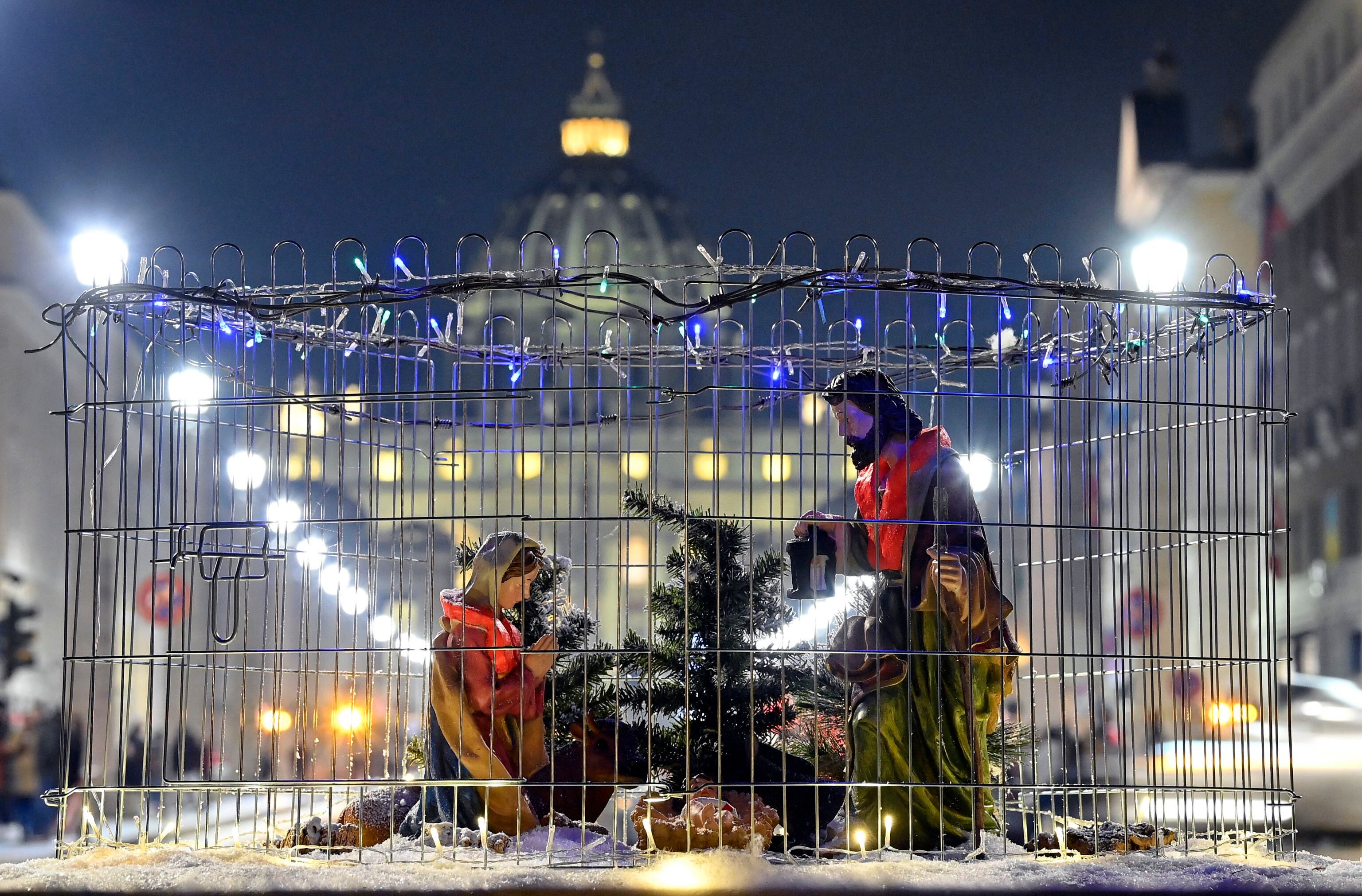 -FOTODELDIA- EA5103. ROMA (ITALIA), 23/12/2022.- Detalle de la obra &quot;El pesebre del migrante&quot; por el artista callejero Harry Greb en una calle de Roma, Italia, con la Basílica de San Pedro al fondo, este viernes. La obra muestra la estampa del pesebre con la Virgen María, San José y el Niño con chalecos salvavidas encerrados en una jaula, en un intento de subrayar la tragedia de los migrantes, refugiados y solicitantes de asilo que se ven forzados a huir de sus hogares en situaciones de vida o muerte. EFE/ Riccardo Antimiani
