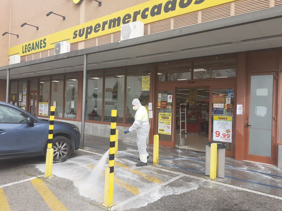 Un operario desinfecta el exterior de un supermercado en la localidad leganense.