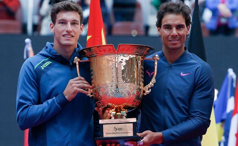 Pablo Carreño Busta y Rafael Nadal posan con el trofeo que les acredita como campeones