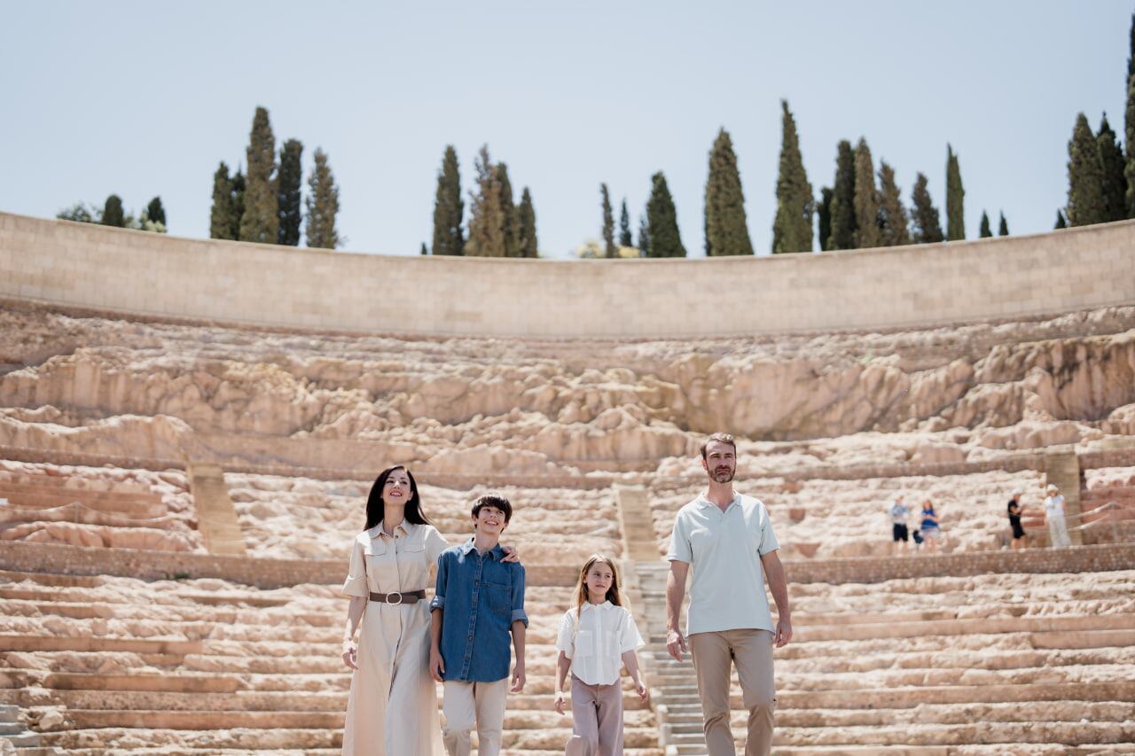 Una familia visita el Teatro Romano de Cartagena durante una estancia en la ciudad