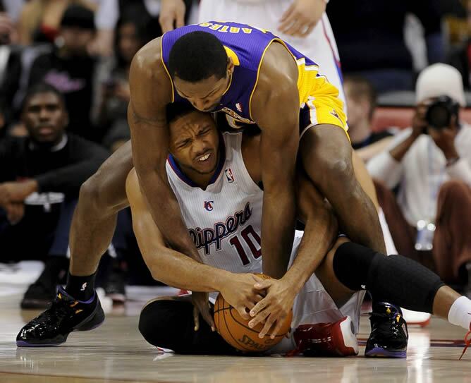 El jugador de Los Ángeles Lakers Ron Artest lucha por el balón con Eric Gordon, de Los Ángeles Clippers, durante la seguna mitad del partido en el que se llevaron la victoria los de Kobe Bryant y Pau Gasol