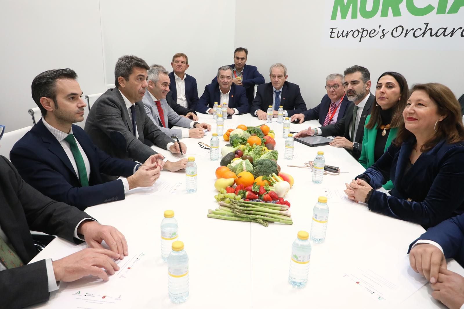 La consejera Sara Rubira durante la reunión celebrada para revindicar la mejora de la competitividad del sector agrario y foto de familia de los asistentes a la reunión en la zona institucional del estand de la Región de Murcia en Fruit Logística