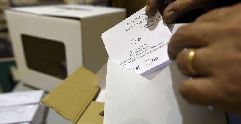 A volunteer places a blank ballot paper into an envelope at a school in Barcelona on November 9, 2014 Catalonia votes on November 9, 2014 in a symbolic vote on independence from Spain. Spain&#039;s Constitutional Court on November 4 ordered the Catalan governm