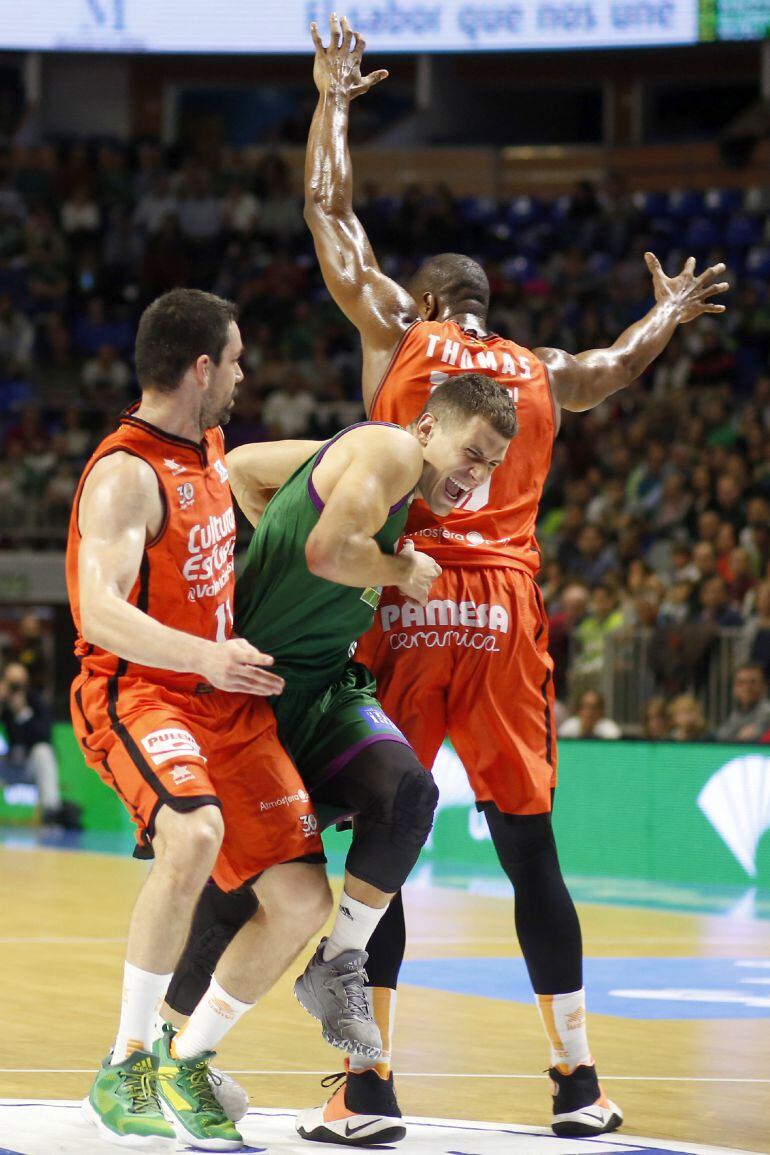 GRA184. MÁLAGA. El escolta servio del Unicaja Nemanja Nedovic (c) intenta pasar entre el escolta Rafa Martinez (i) y ala-pívot georgiano Will Thomas (d), del Valencia Basket, durante el partido de la duodécima jornada de la Liga ACB que se disputa esta ta