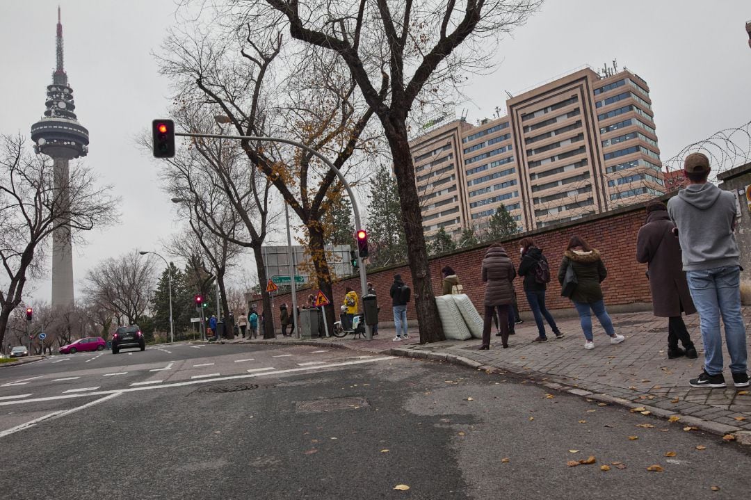 Varias personas hacen cola en las inmediaciones de los Laboratorios Unilabs situados en la calle Juan Esplandiú para realizarse pruebas de detección del COVID-19, en Madrid