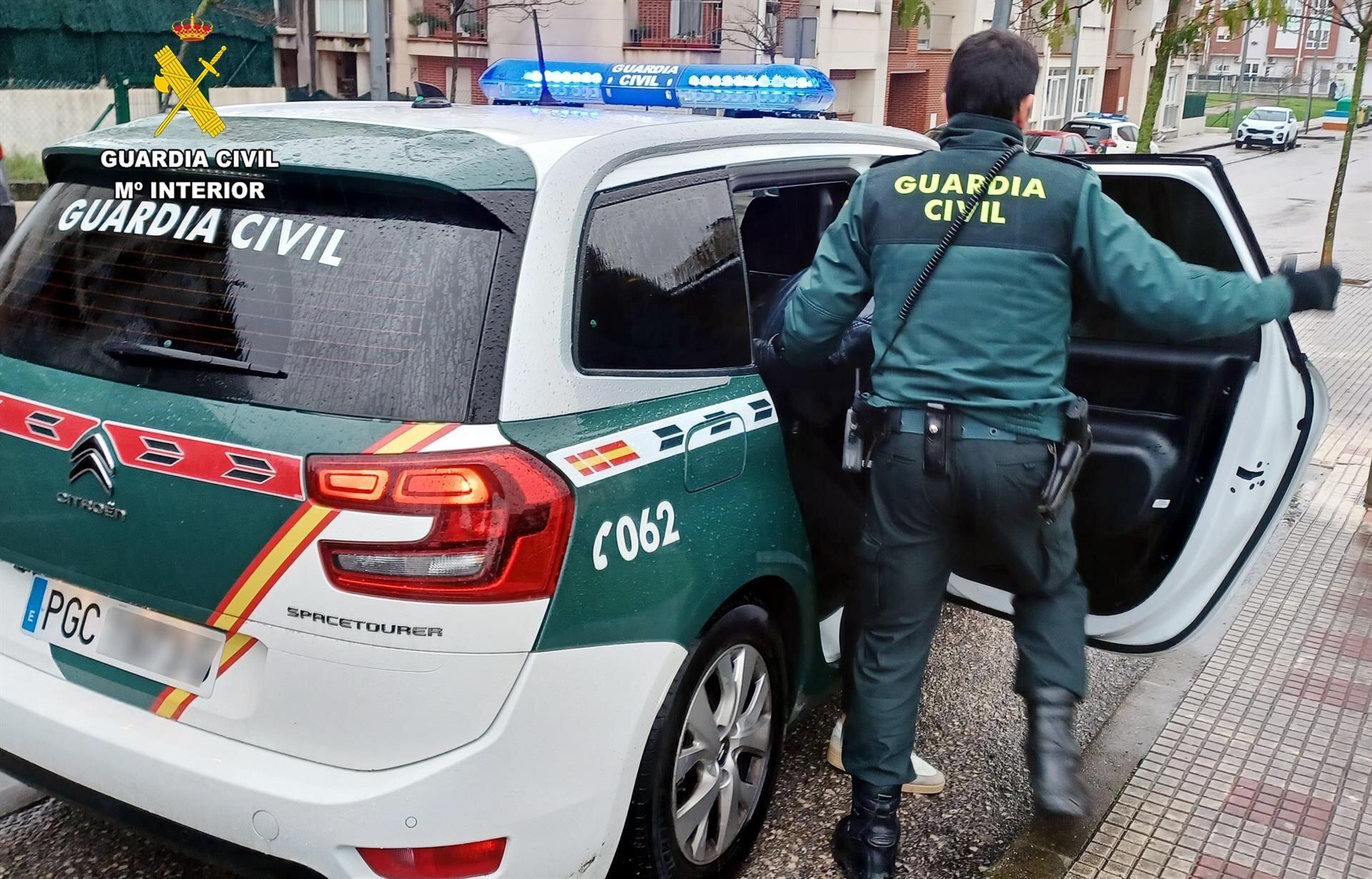 Un agente de la Guardia Civil junto a su vehículo.