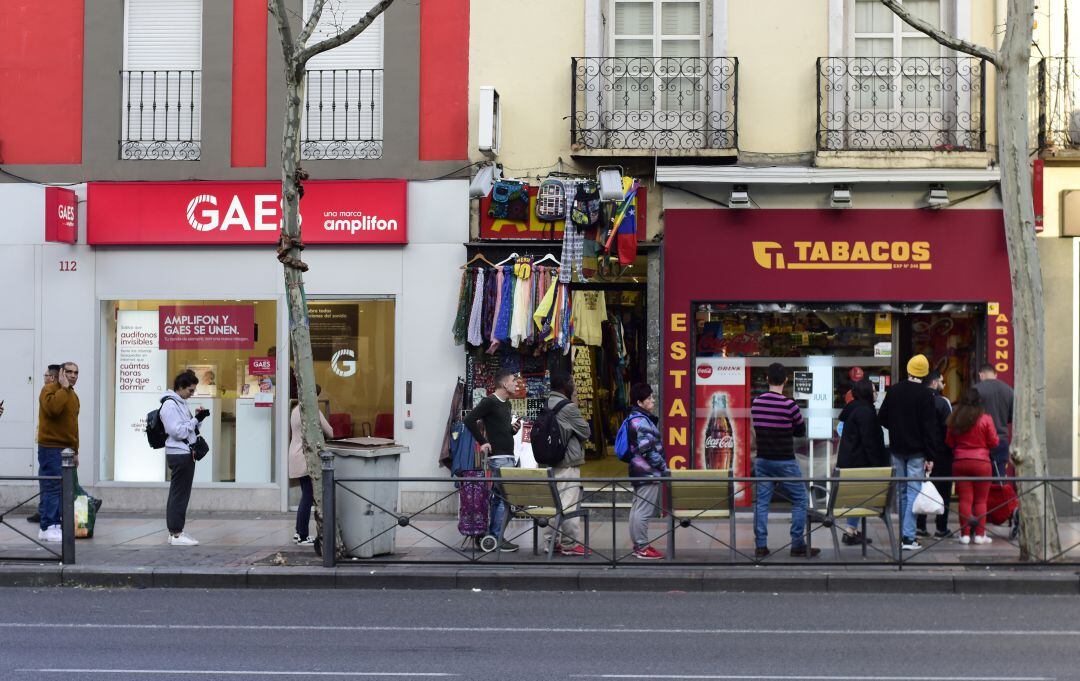 Varias personas hacen cola frente a un estanco durante el inicio del confinamiento.