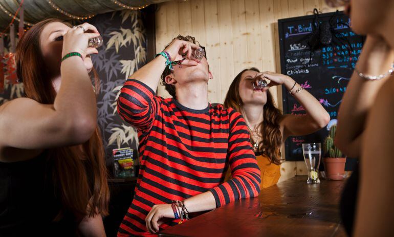 Jóvenes beben en un bar. 