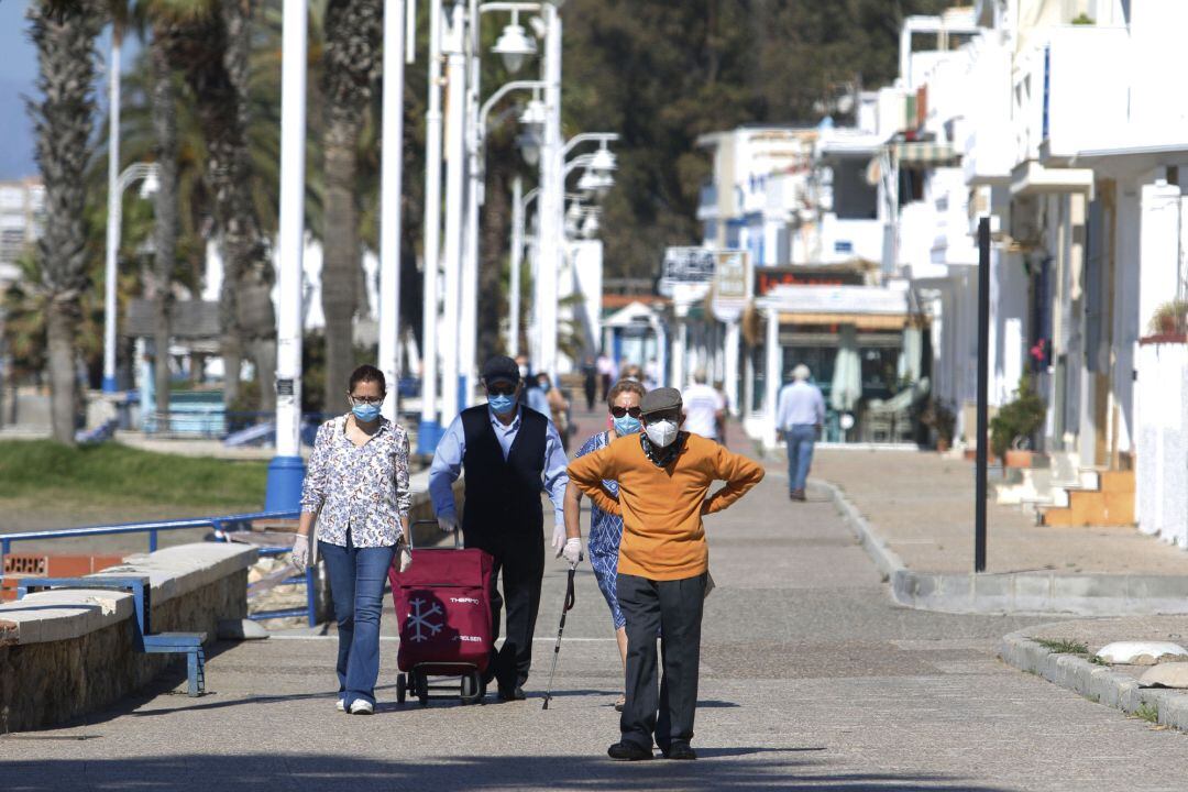 Personas mayores recorren el paseo marítimo por la zona de La Malagueta