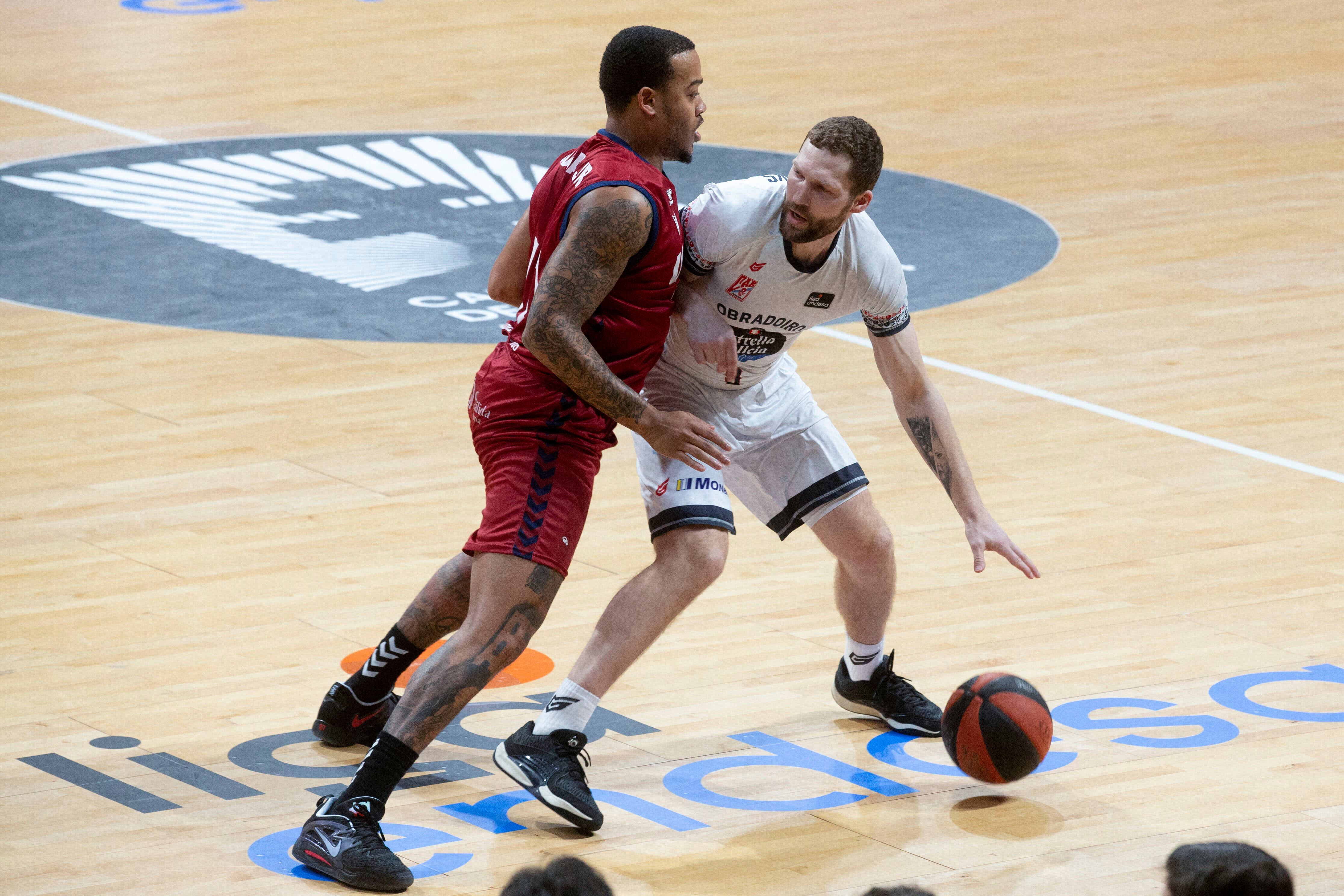 MURCIA, 16/03/2024.- El base letón de Monbus Obradoiro Janis Strelnieks (d) controla el balón ante la presión del base estadounidense de UCAM Murcia Troy Coupain (i), durante el partido de la vigésimo quinta jornada Liga Endesa, que están disputando este sábado en el Palacio de los Deportes de Murcia. EFE/Marcial Guillén
