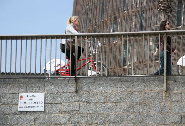 Una ciclista circula amb una bicicleta del Bicing pel front marítim de Barcelona.