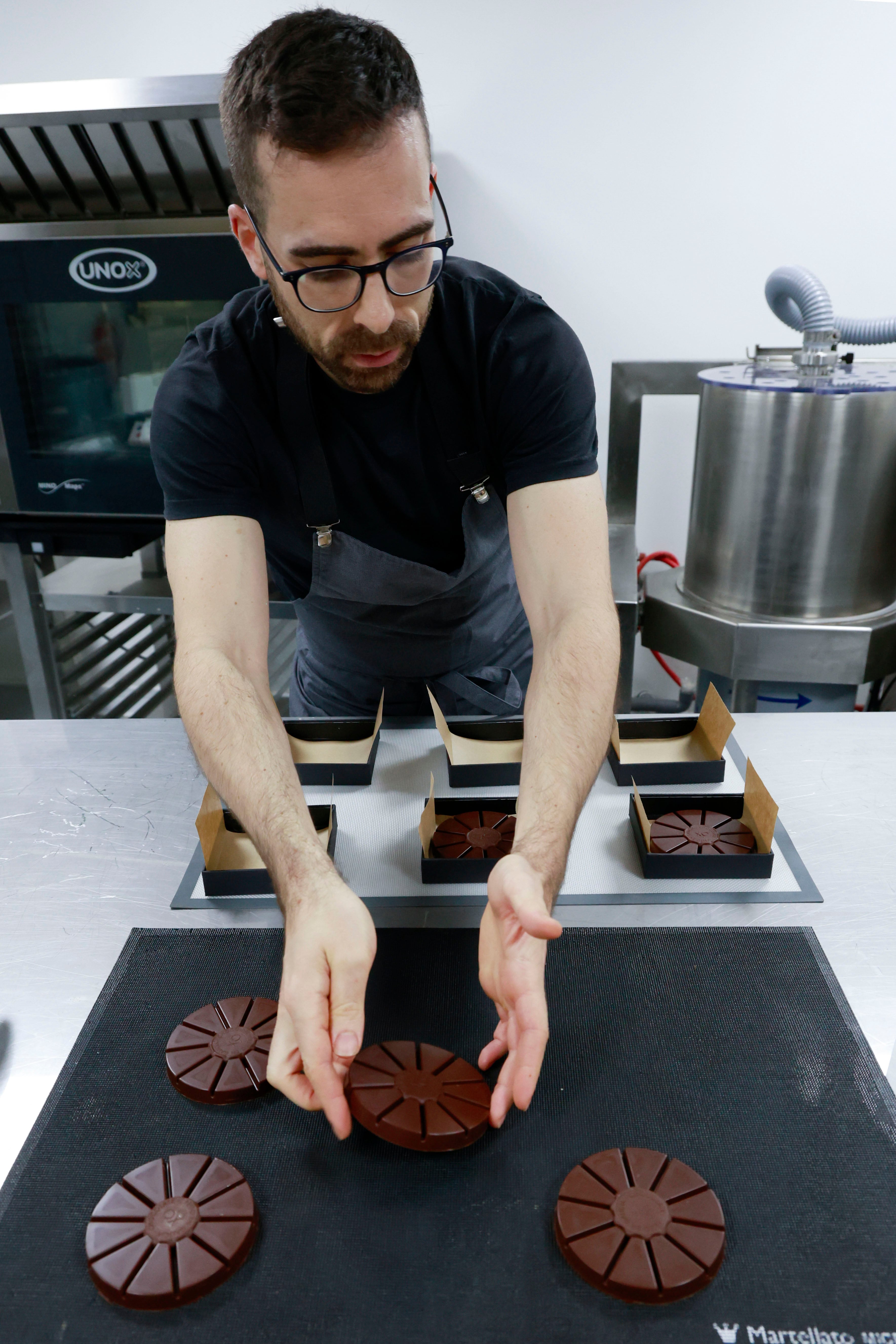 Pontedeume, 12/12/2024.-Un año después de su estreno, la marca de chocolates Oxóco, que los elabora con productos como alga percebe o eucalipto, se lanza al mercado de los turrones con una apuesta por recuperar los sabores tradicionales del producto protagonista de la Navidad; en la imagen, Tomás Rodríguez en su obrador dando los últimos toques a unos turrones. EFE/ Kiko Delgado.