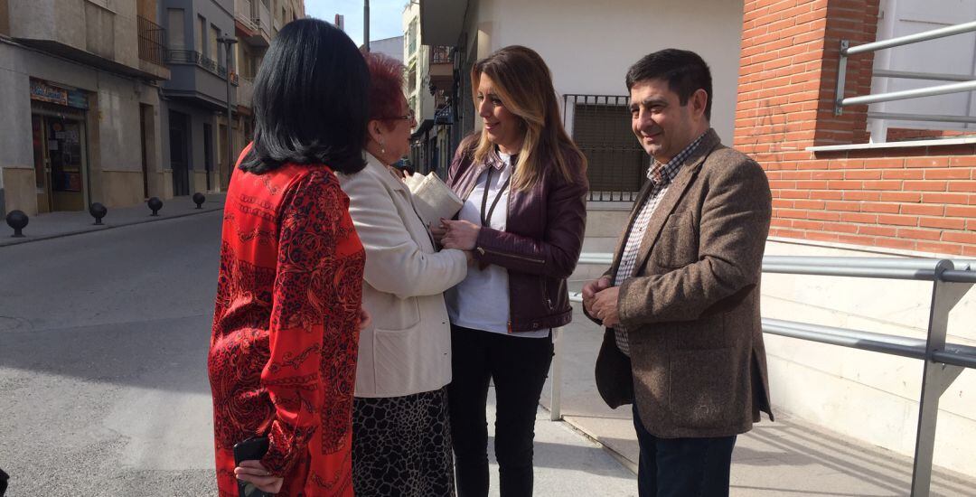 La secretaria del PSOE andaluz, Susana Díaz, saluda a una vecina de Torredelcampo ante la presencia del máximo responsable de los socialistas en la provincia, Francisco Reyes.