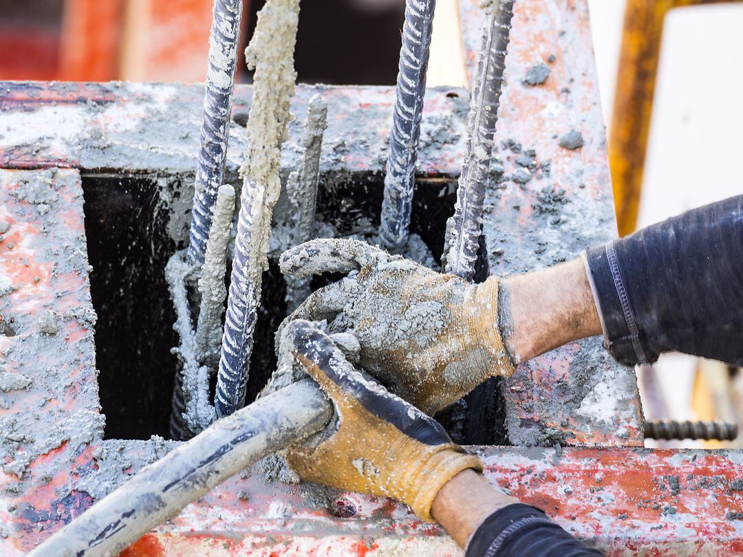 Un obrero maneja material de construcción en una obra. 