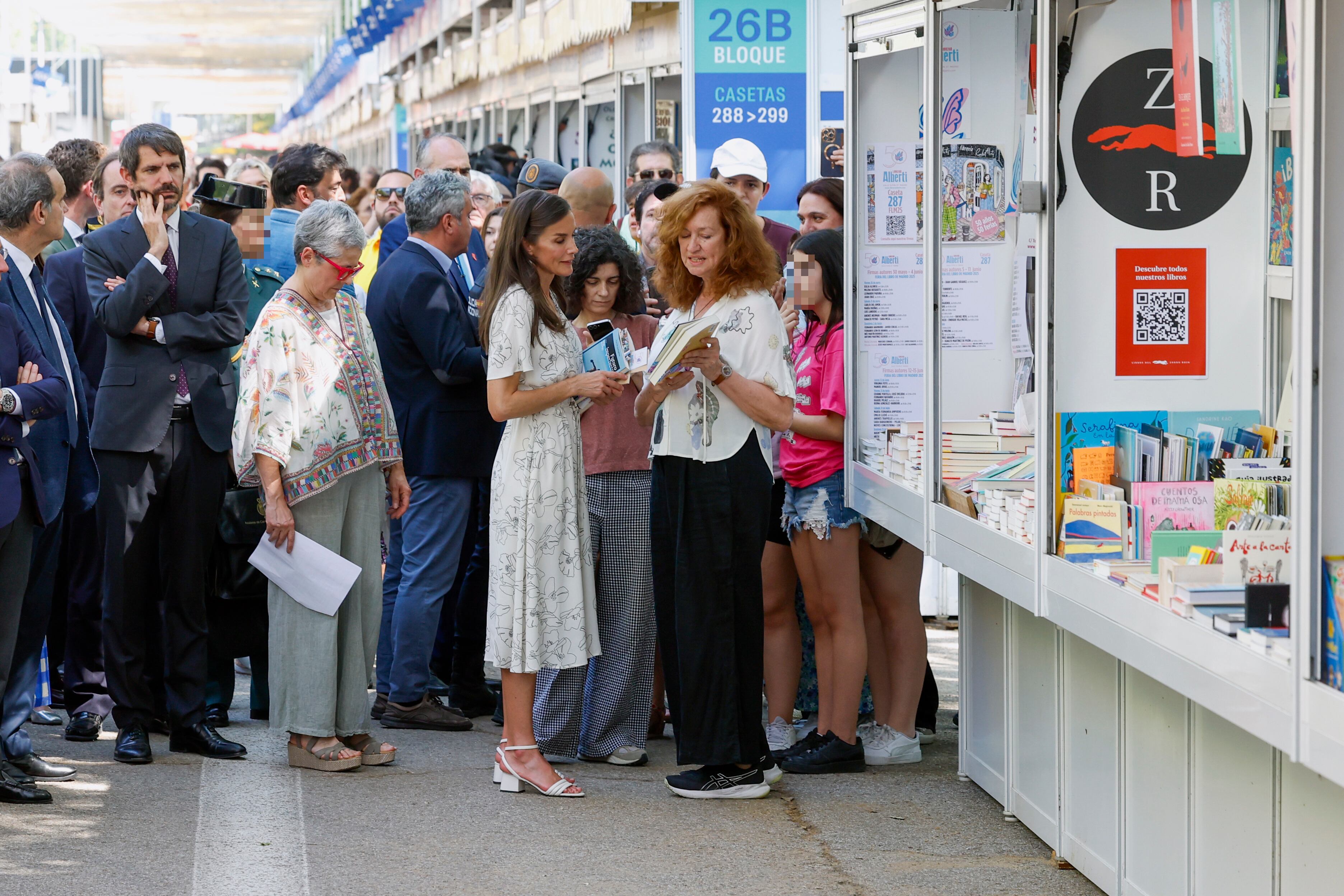La reina Letizia (c), la directora de la Feria del Libro de Madrid, Eva Orúe (2i) y el ministro de Cultura, Ernest Urtasun (i) visitan las casetas de la Feria del Libro de Madrid este viernes durante la inauguración de su 84.ª edición.