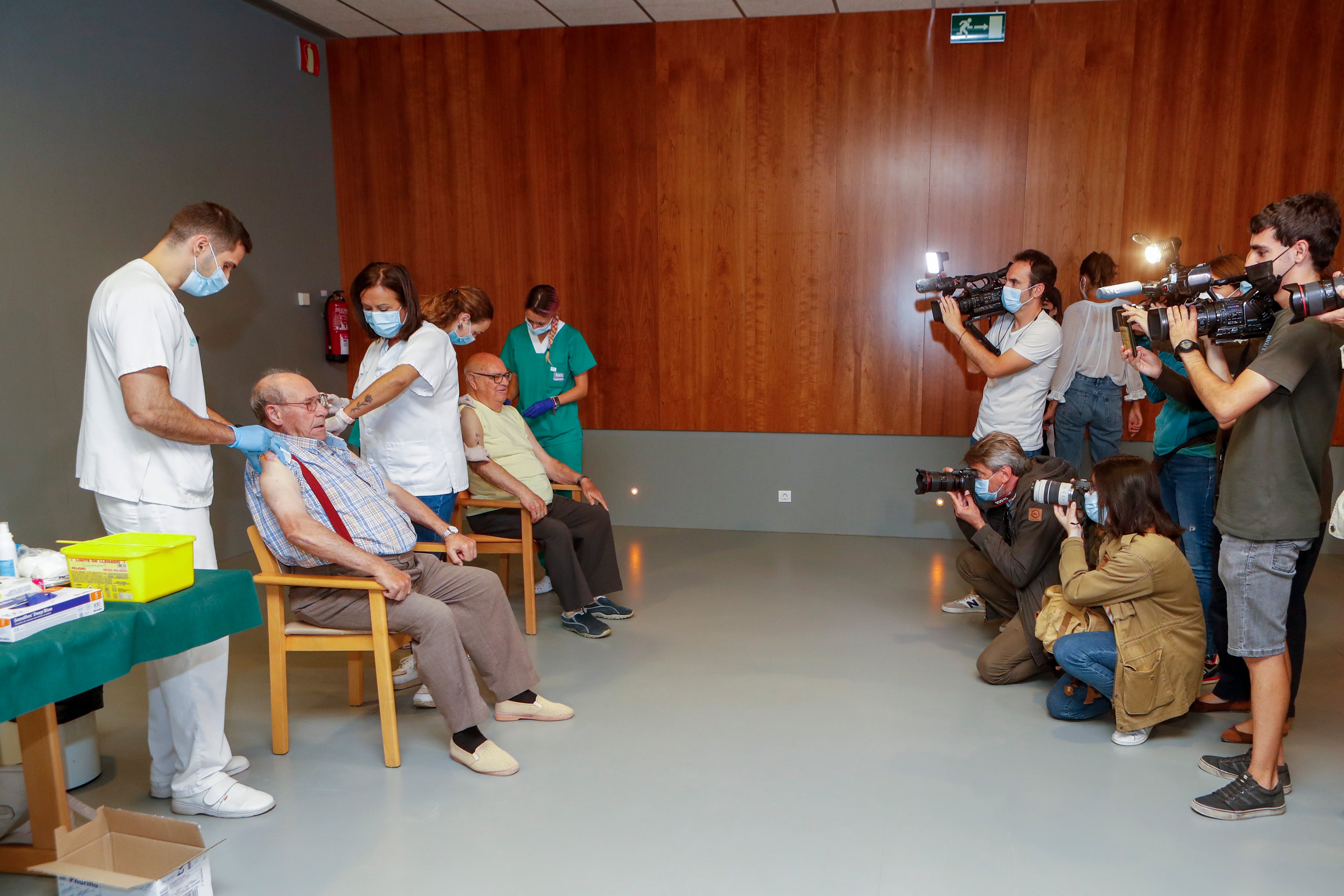 ZARAGOZA, 26/09/2022.- La residencia pública Elías Martínez, en Zaragoza, ha sido el escenario elegido para el arranque de la campaña de vacunación de la gripe y de la cuarta dosis de la vacuna frente al Covid-19. En la imagen, varios medios asisten al acto de vacunación, este lunes. EFE/Javier Belver
