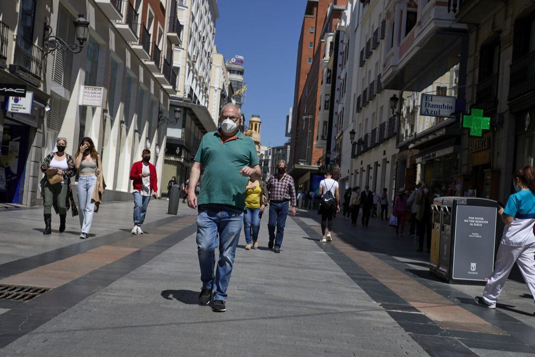 Varias personas pasean por las inmediaciones de la Puerta del Sol con mascarilla, a 7 de mayo de 2021, en Madrid (España).