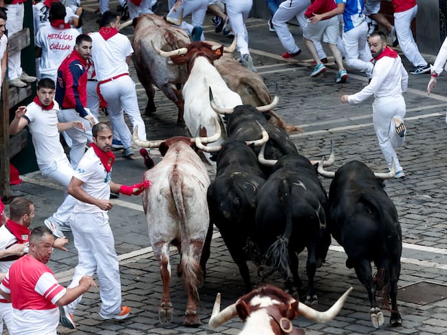os toros de la ganadería de Jandilla enfilan Mercaderes tras pasar por la plaza del Ayuntamiento durante el sexto encierro de los Sanfermines 2024
