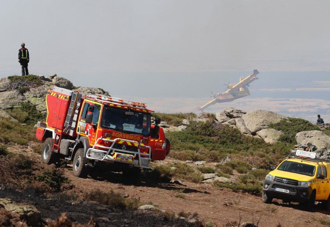 Un camión de bomberos y un vehículo de las brigadas forestales durante los trabajos trabajan en el incendio de La Granja.