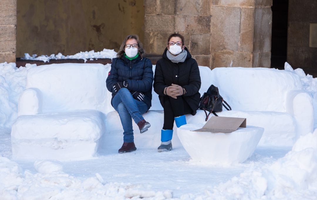 Dos mujeres sentadas sobre un banco de nieve en Albarracín, Teruel.