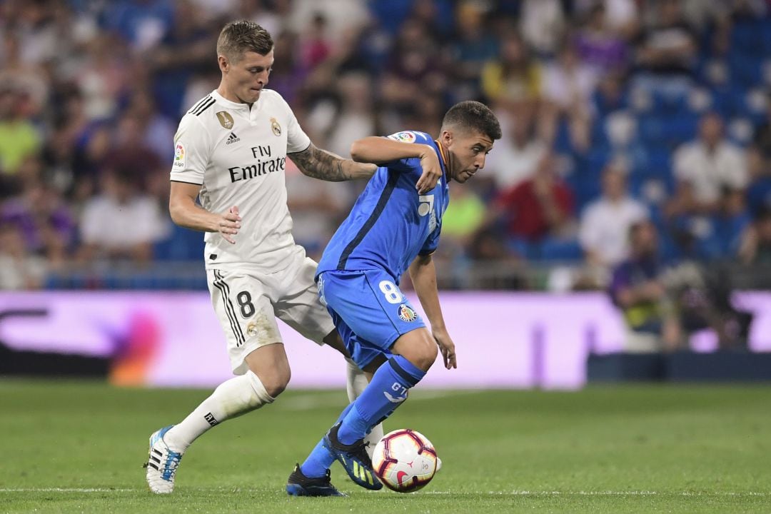 El azulón Francisco Portillo controla el balón ante la presión del madridista Toni Kroos durante el encuentro que Getafe C.F. y Real Madrid C.F. disputaron en el Santiago Bernabéu.