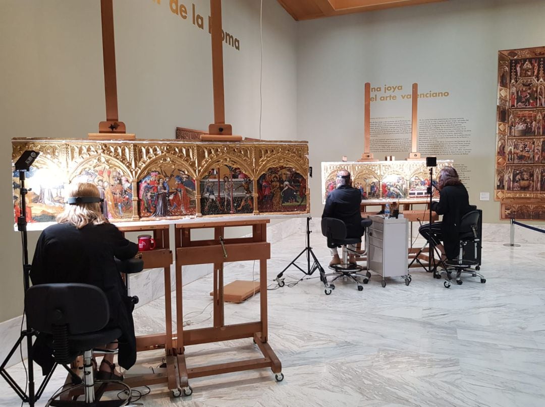 Técnicos trabajando en la restauración de la predela del Centenar de la Ploma