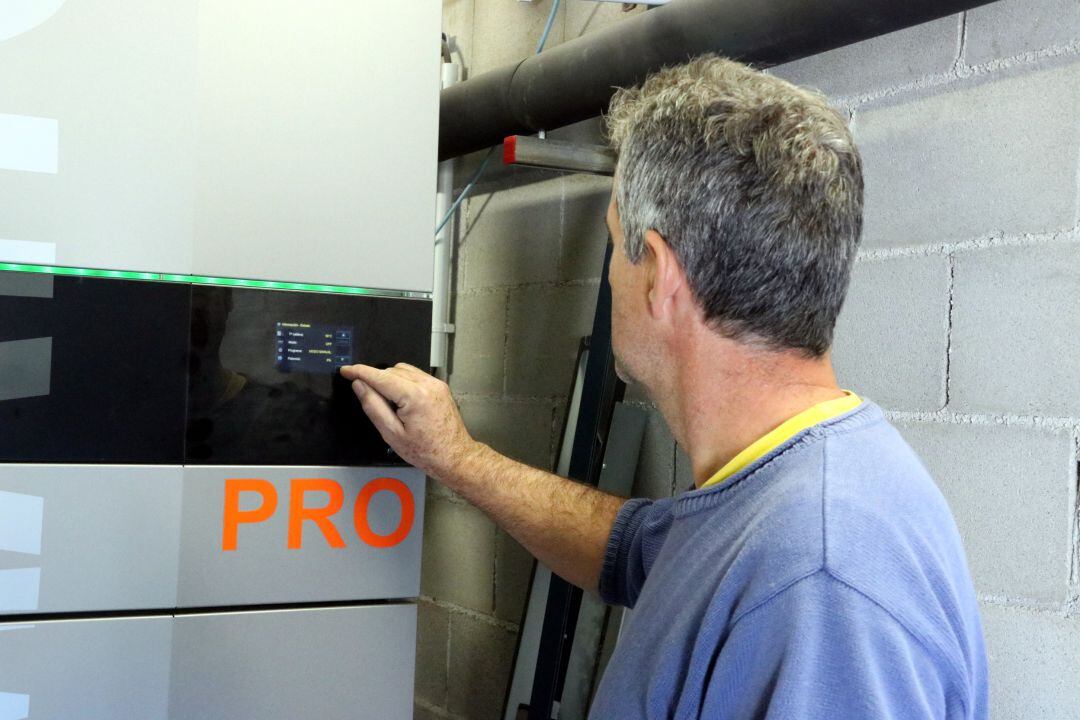 Un tècnic programant una caldera de biomassa a Besalú