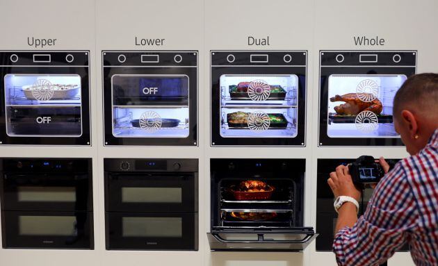 Un hombre fotografía los nuevos hornos de Samsung.