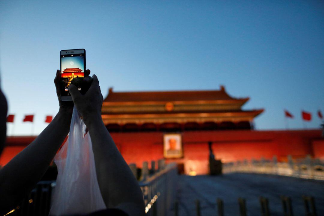 Una mujer fotografía la Puerta de Tiananmen en Pekín con su móvil