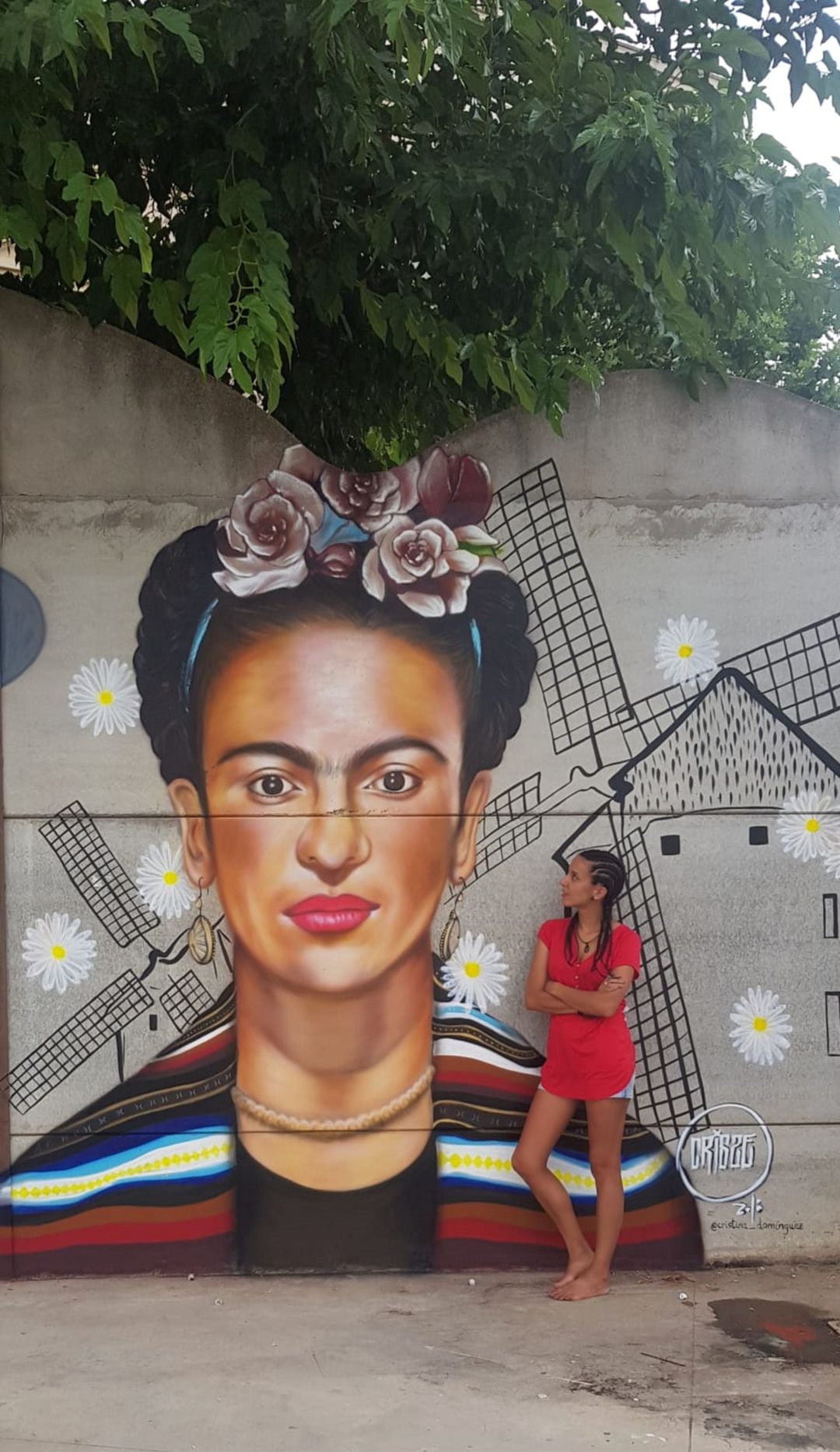 La artista iniestense posa junto a uno de sus murales 