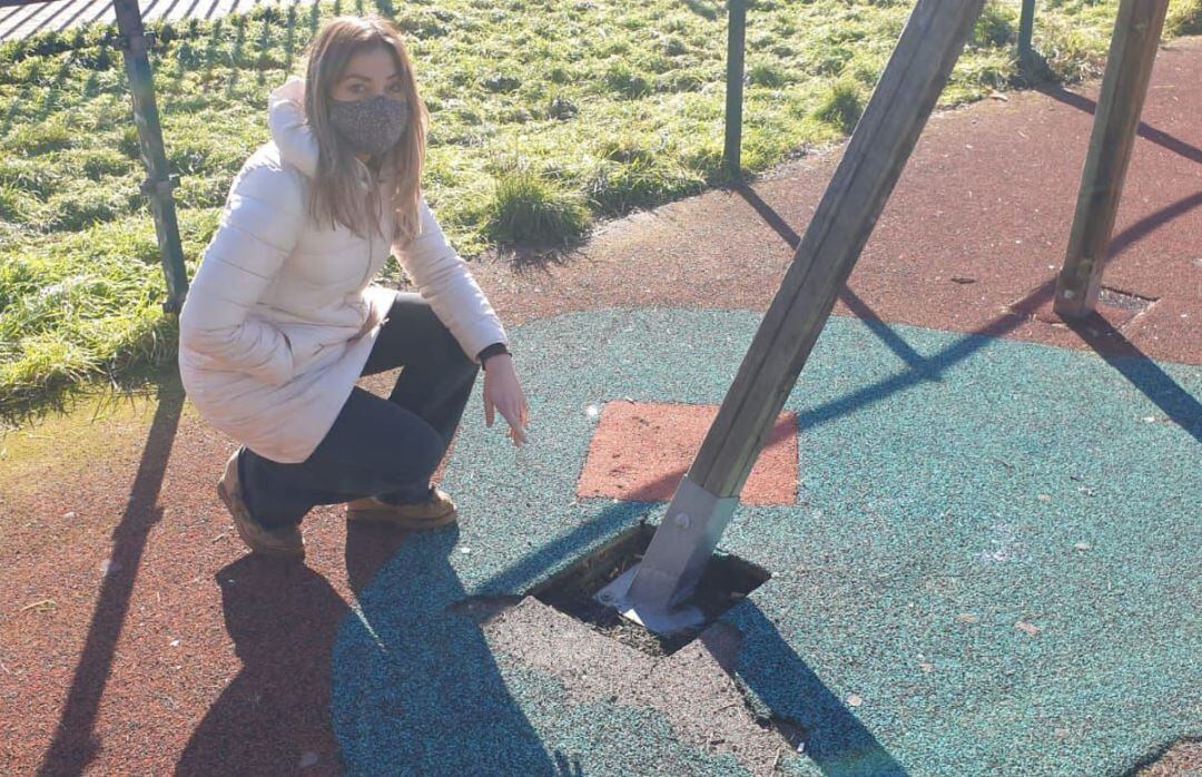 La portavoz municipal del PP, Carolina Blasco, señala el mal estado de una zona de juegos infantiles
