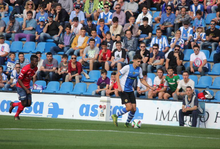 Alex Muñoz perseguido por un jugador del Olot, en el Rico Pérez