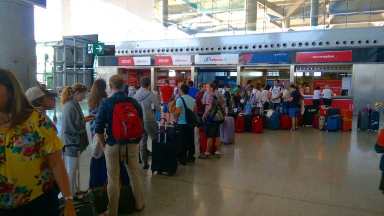 Viajeros haciendo cola ante el mostrador de Delta Airlines en Málaga para protestar por la cancelación de su vuelo a Nueva York