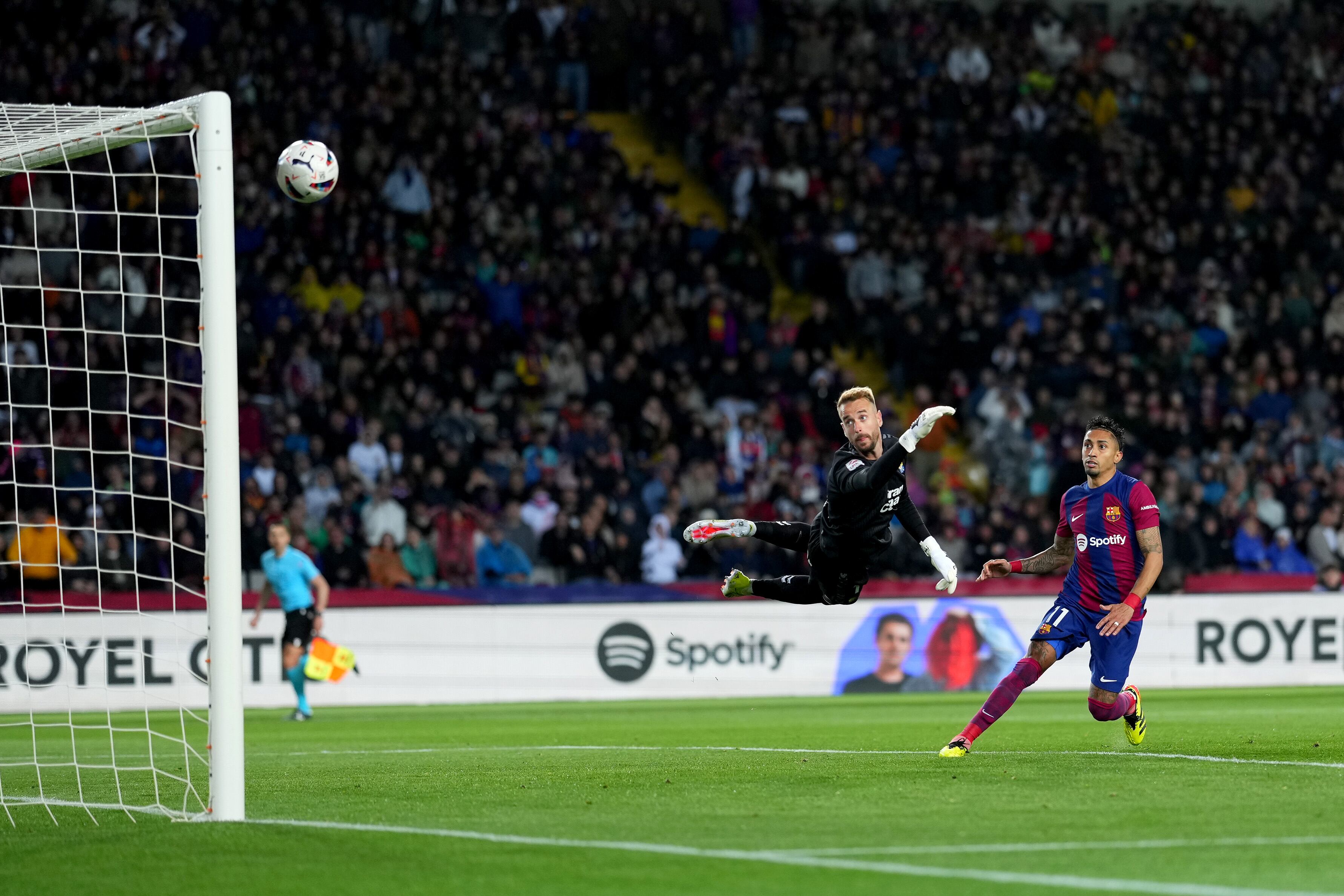 BARCELONA, SPAIN - MARCH 30: Raphinha of FC Barcelona scores his team's first goal past Aaron Escandell of UD Las Palmas during the LaLiga EA Sports match between FC Barcelona and UD Las Palmas at Estadi Olimpic Lluis Companys on March 30, 2024 in Barcelona, Spain. (Photo by Alex Caparros/Getty Images)
