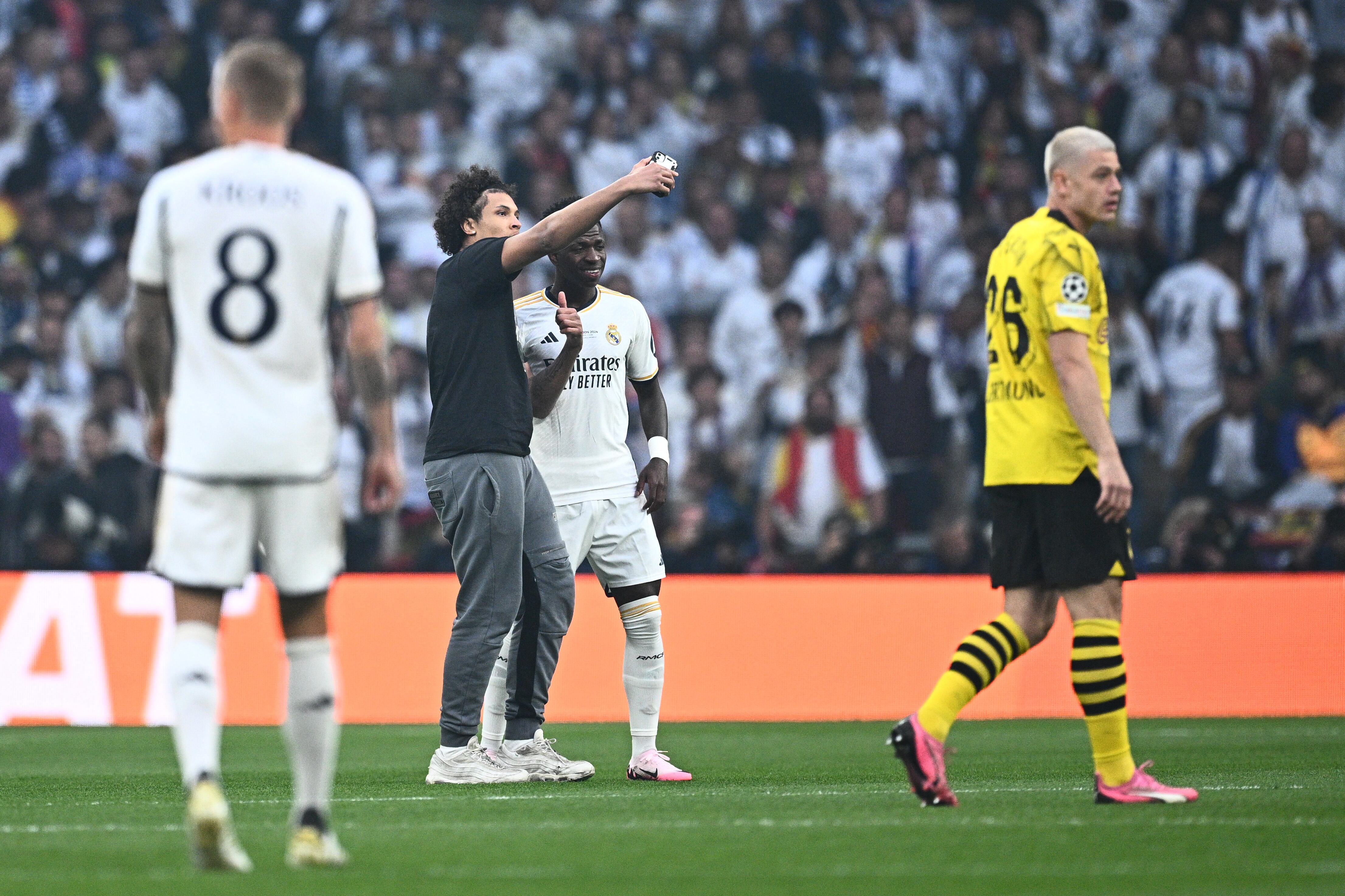 Un espontáneo se hace una foto con Vinicius durante la final de la Champions League