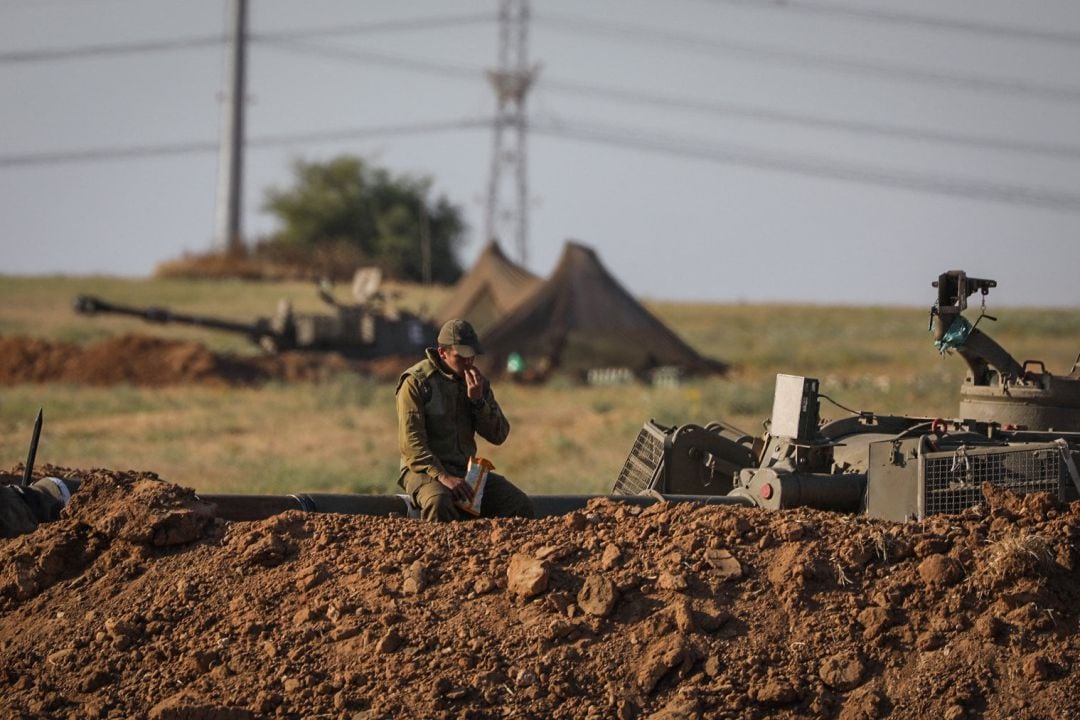 Un soldado de las Fuerzas de Defensa de Israel descansa sobre el cañón de un arma cerca en la frontera entre Gaza e Israel