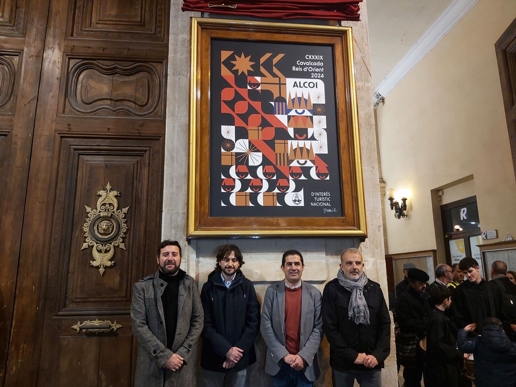 Las autoridades y al autor del cartel posan bajo su obra