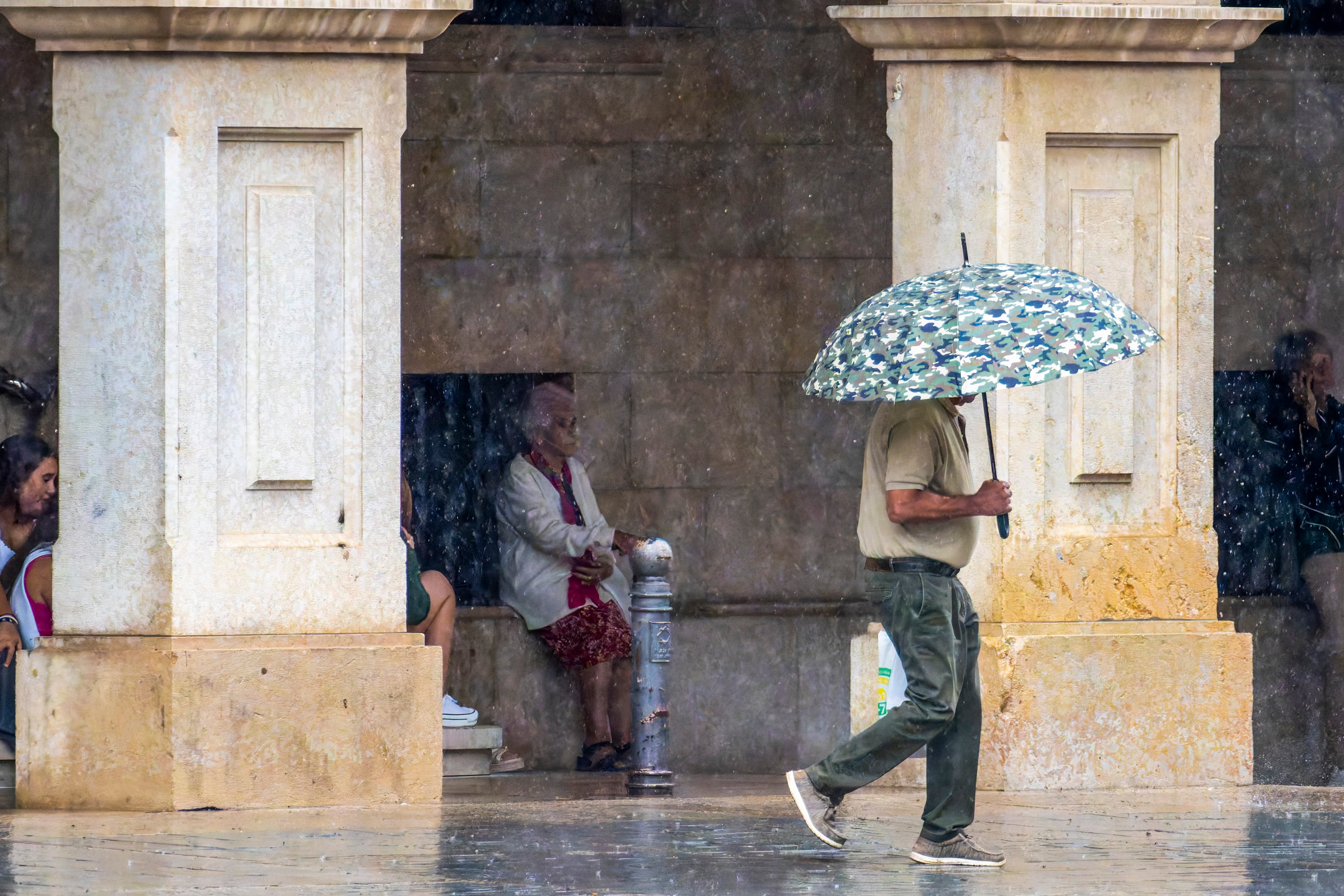 Un hombre se refugia de la lluvia en Teruel.