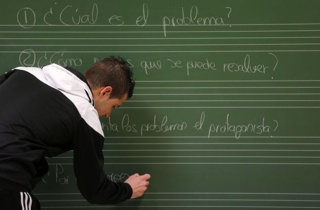 Un profesor escribe en un clase del colegio público &quot;San Miguel Arcangel&quot;, en Escalada (Burgos).