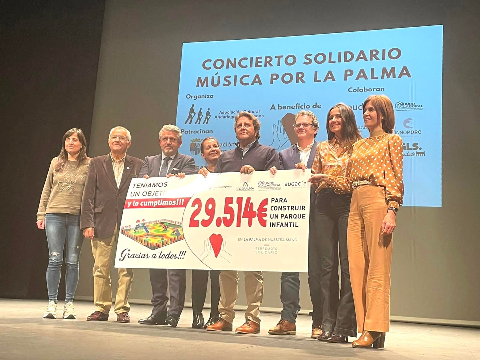 Organizadores de la inciativa En la Palma de Nuestra Mano sostienen un cheque simbólico